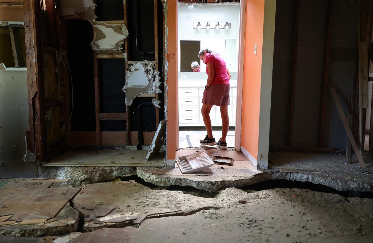 Sallie Reeves in a room with huge cracks on the floor