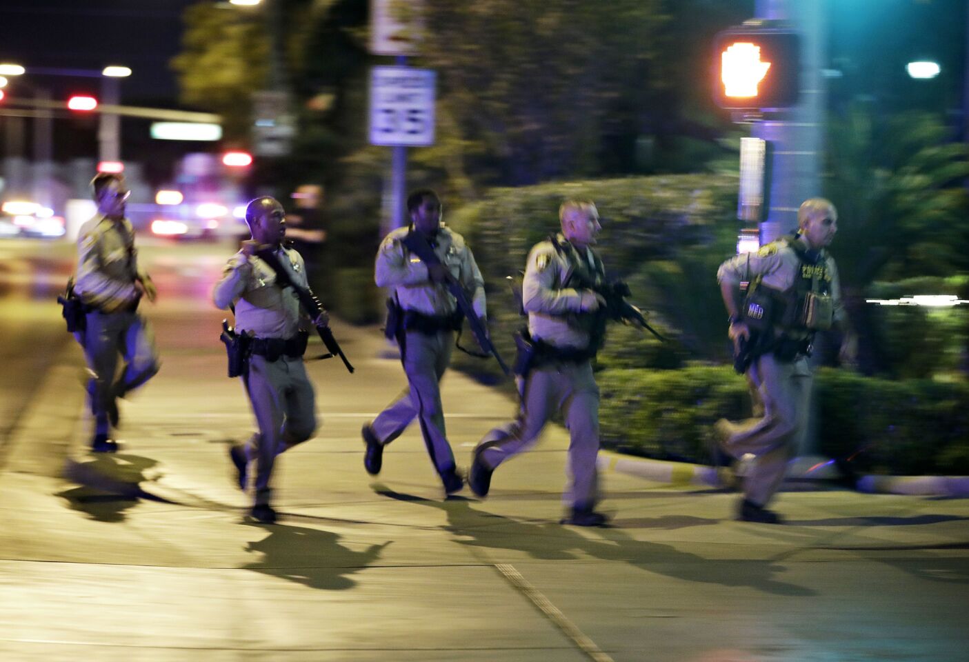 Police run to cover at the scene of a shooting near the Mandalay Bay resort and casino on the Las Vegas Strip.