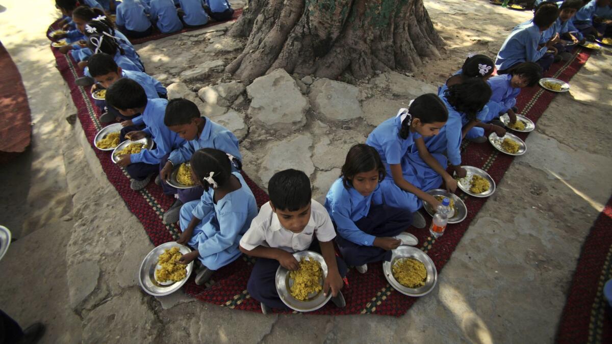 Indian schoolchildren eat a free midday meal, provided on all working days at a government school on the outskirts of Jammu, in 2009. Asia is the continent with the highest number of hungry people — about 526 million.