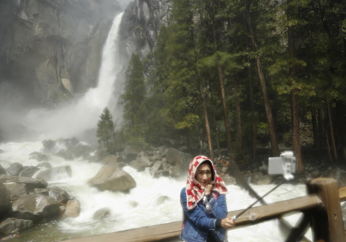 A woman takes a selfie at Lower Yosemite Falls. Would you still go to a destination if you weren't allowed to take a photo?