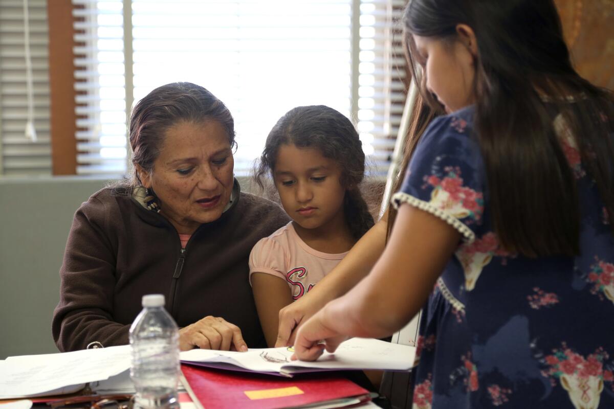 Virginia Carmelo and her granddaughter Virginia Paveen Sanchez, 6, look at illustrations by her other granddaughters during a monthly Tongva language class.
