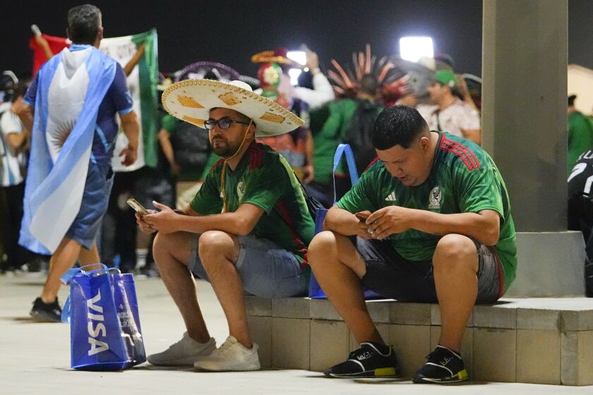 Mexico supporters sit outside Lusail Stadium following following Argentina's 2-0 victory over Mexico in a World Cup group C soccer match in Lusail, Qatar, Suday, Nov. 27, 2022. (AP Photo/Julio Cortez)