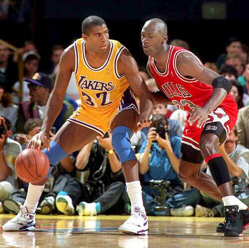 Magic Johnson of the Los Angeles Lakers dribbles against Michael