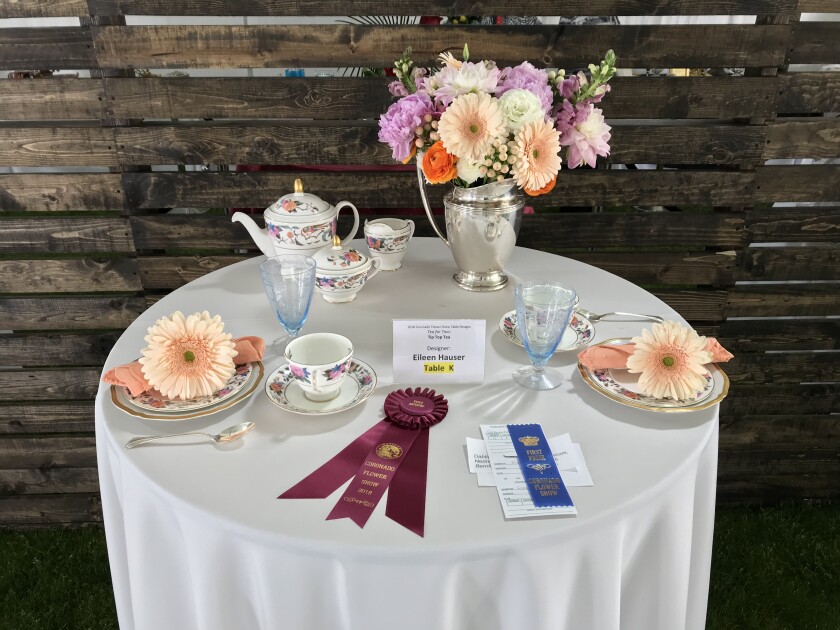 A tablescape adorned with flowers and china has prize ribbons for its "tea for two" design.