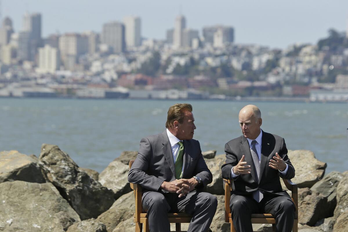 Former Gov. Arnold Schwarzenegger sits with Gov. Jerry Brown on Treasure Island last month before the signing of new climate change legislation.