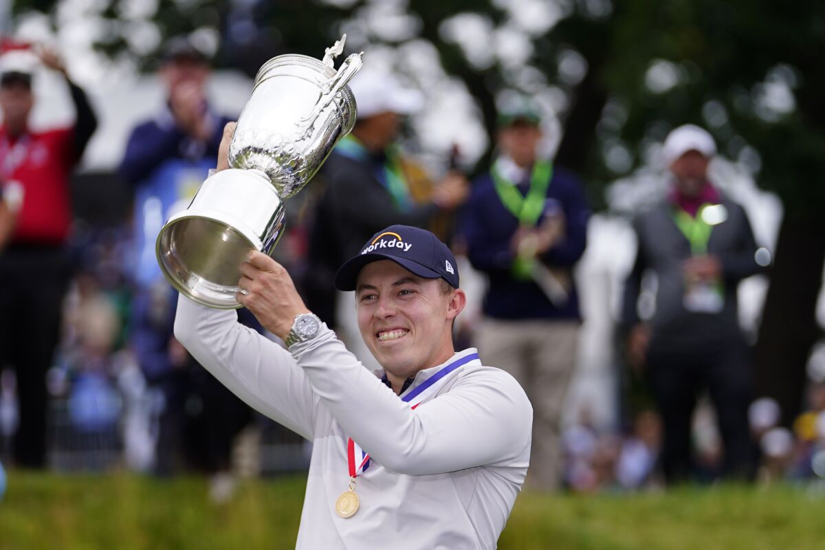 Matt Fitzpatrick hoists the trophy after winning the U.S. Open golf tournament.
