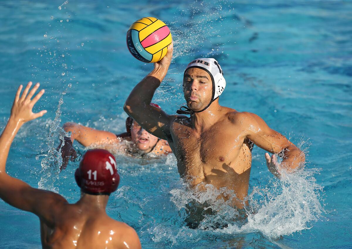 Huntington Beach's Cooper Haddad shoots and scores over Laguna Beach's William Kelly in a Surf League match on Wednesday at Corona del Mar High.