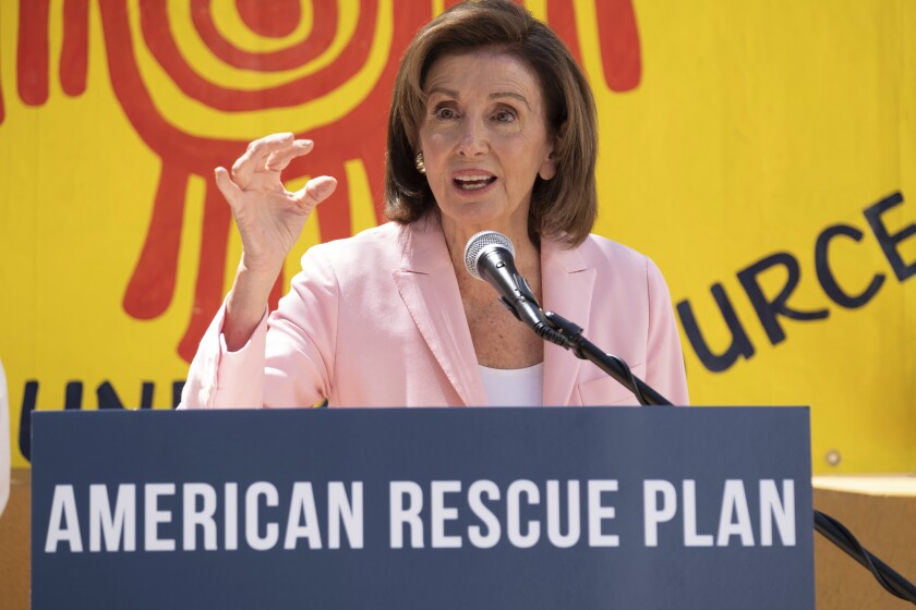 House Speaker Nancy Pelosi speaks at a podium.