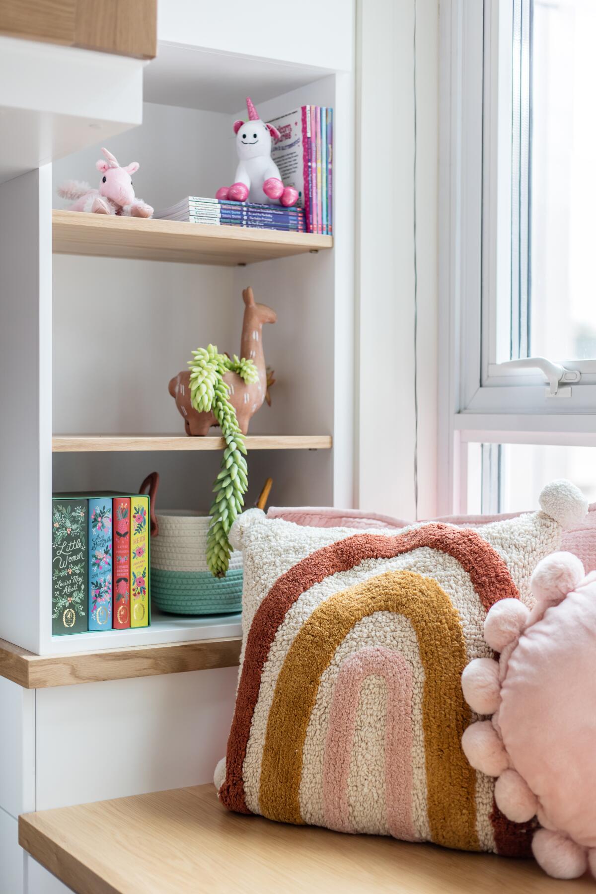 Colorful accents and soft pillows rest on shelves in the girls' shared bedroom. 