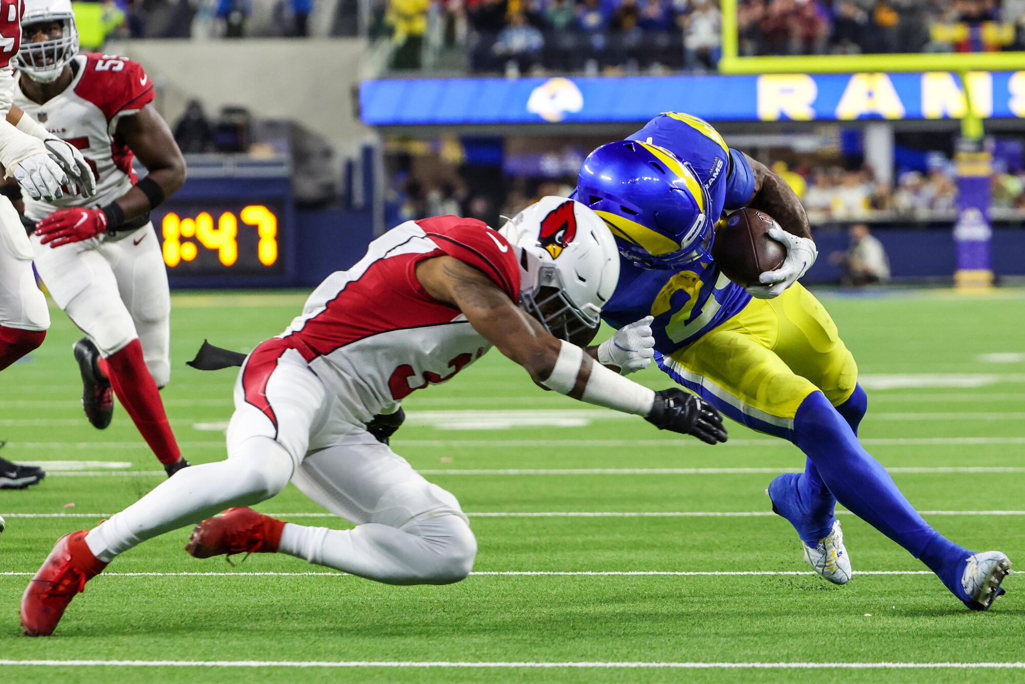 Arizona Cardinals safety Budda Baker and Rams running back Cam Akers collide during a play in the third quarter.