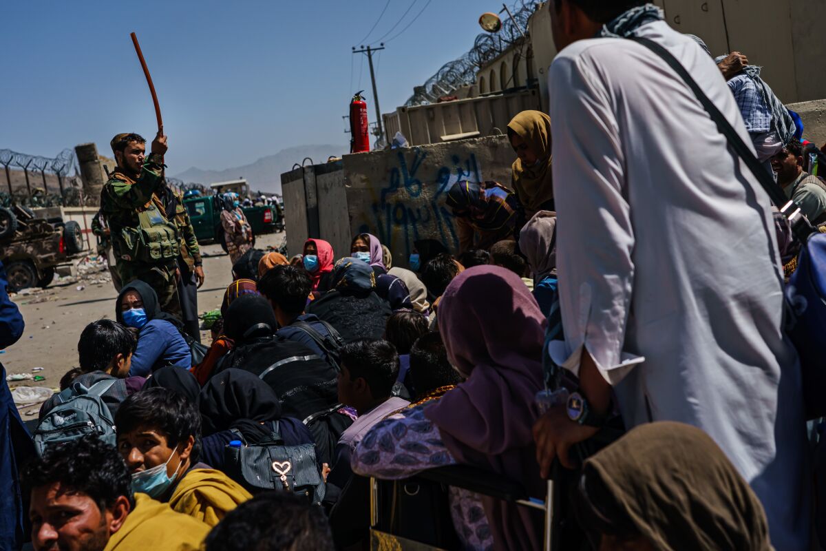 Afghans wait at a Taliban-controlled checkpoint