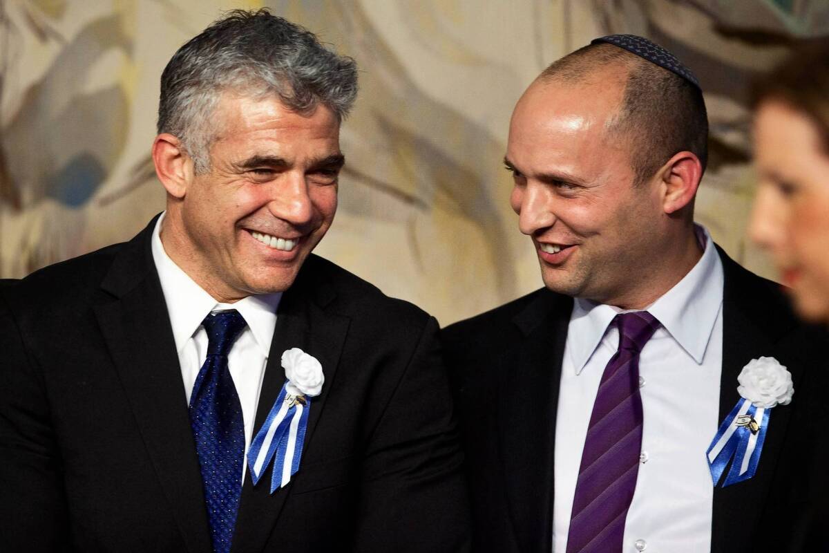 Rivals Yair Lapid, left, leader of the Yesh Atid party, and Naftali Bennett, head of the Jewish Home party, attend a reception this month in Jerusalem. Both support a military draft for the ultra-Orthodox.