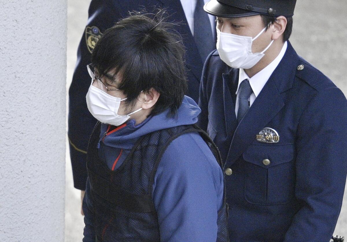 Tetsuya Yamagami, who is accused of killing Japan's Shinzo Abe, is led to a police station Tuesday.