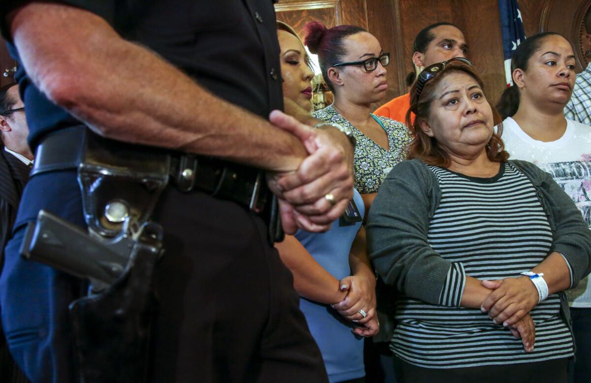 Francisca Xuncax, mother of a 13-year-old victim in a triple shooting in South L.A., listens to Mayor Eric Garcetti at a news conference.