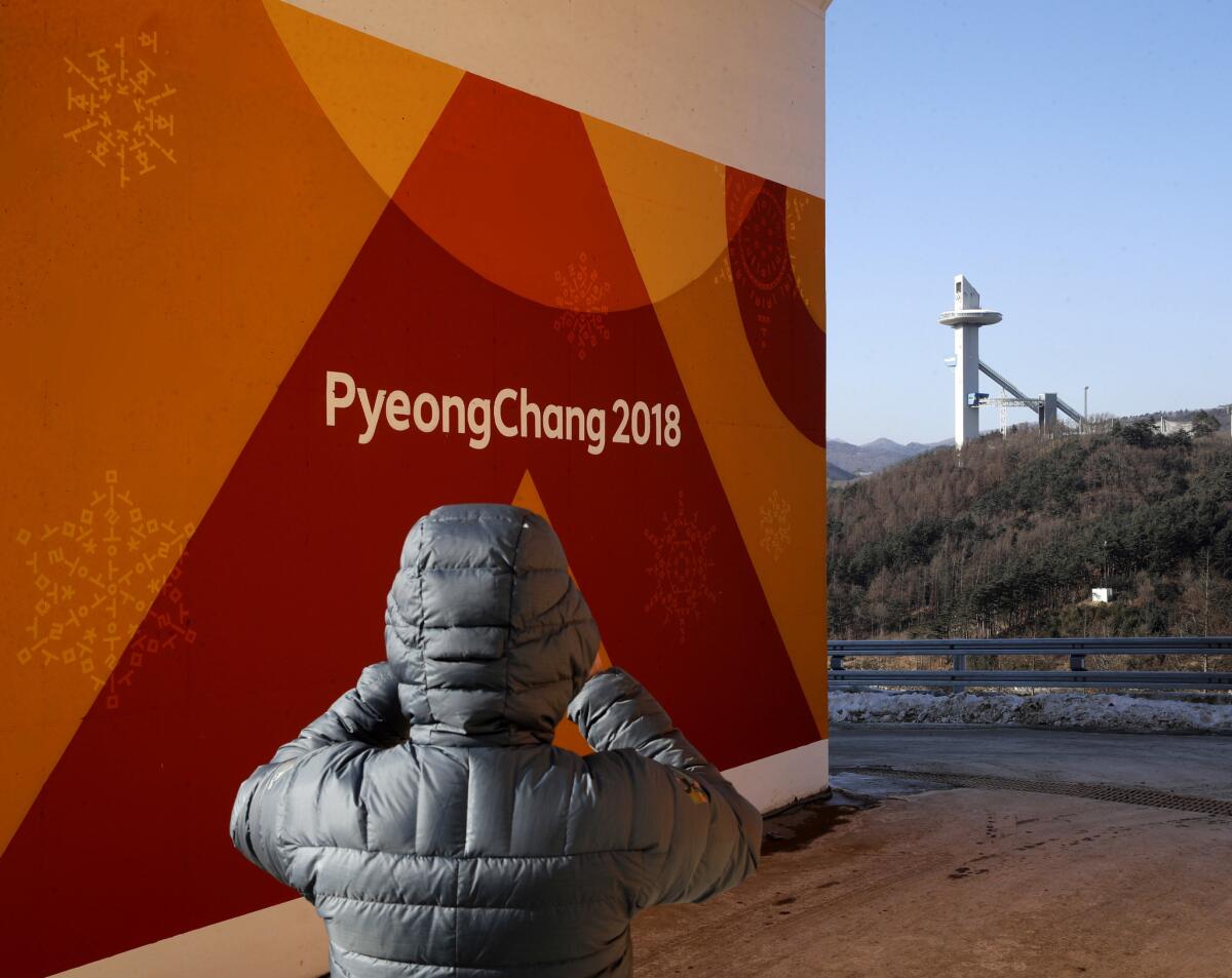 A member of the German luge team takes photos of the Alpensia Ski Jumping Center near Pyeonghcang, South Korea..