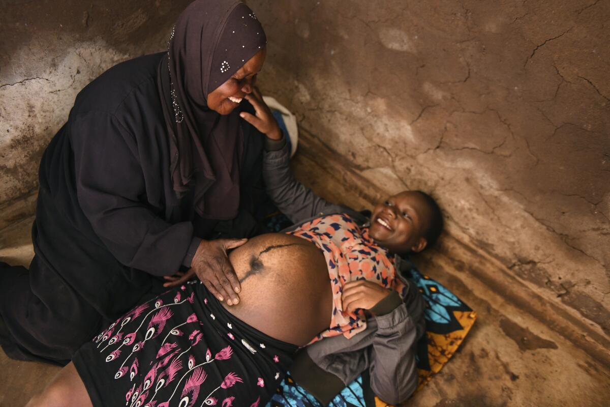 Lucy Mbewe, a traditional birth attendant attends to a pregnant woman at her home, in Simika Village, Chiradzulu, southern Malawi on Sunday, May 23, 2021. Health officials in Malawi say fewer women are getting prenatal care amid the COVID-19 pandemic. At risk are the developing country's gains on its poor rate of maternal deaths. (AP Photo/Thoko Chikondi)