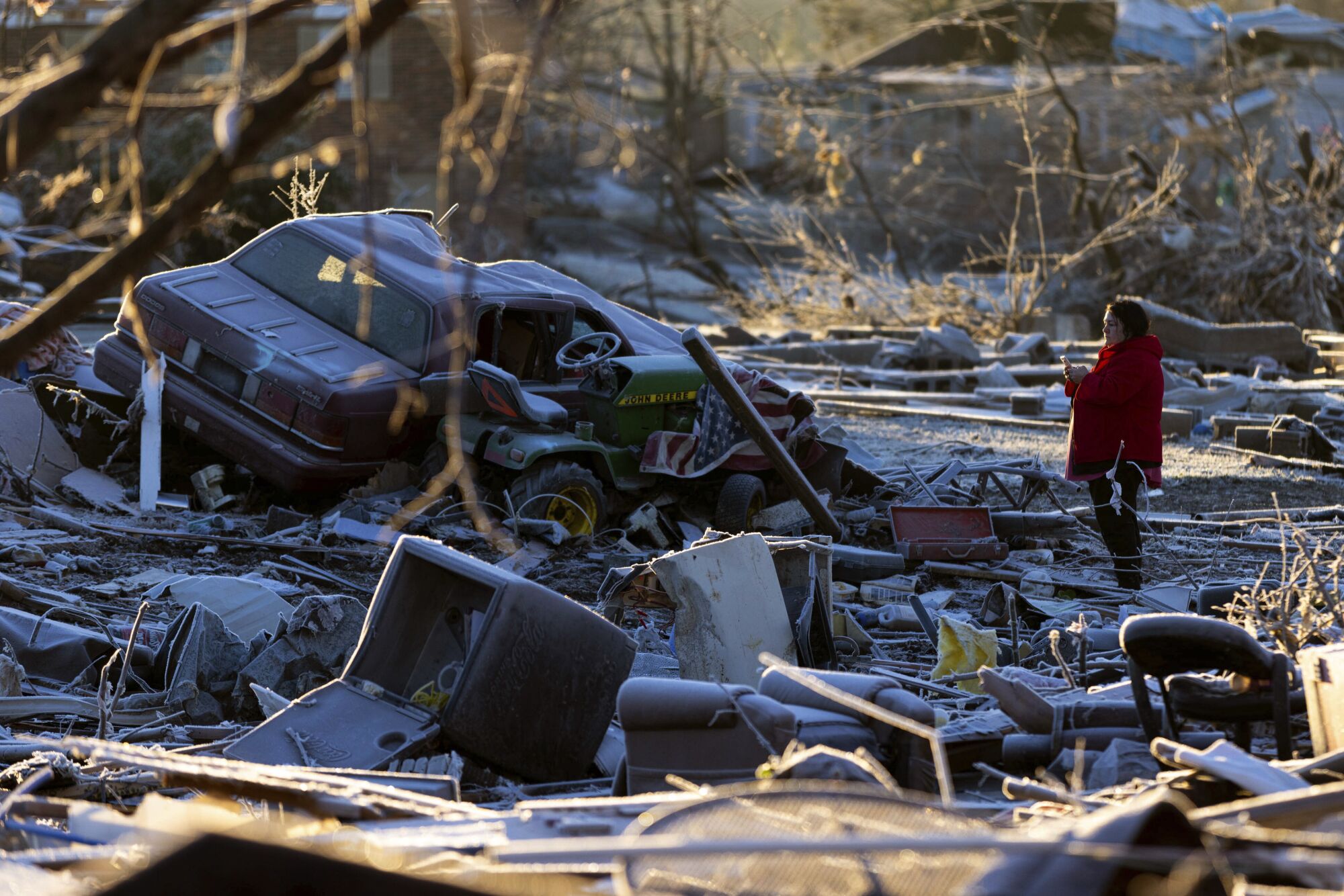 A woman stands in the ruins of her home