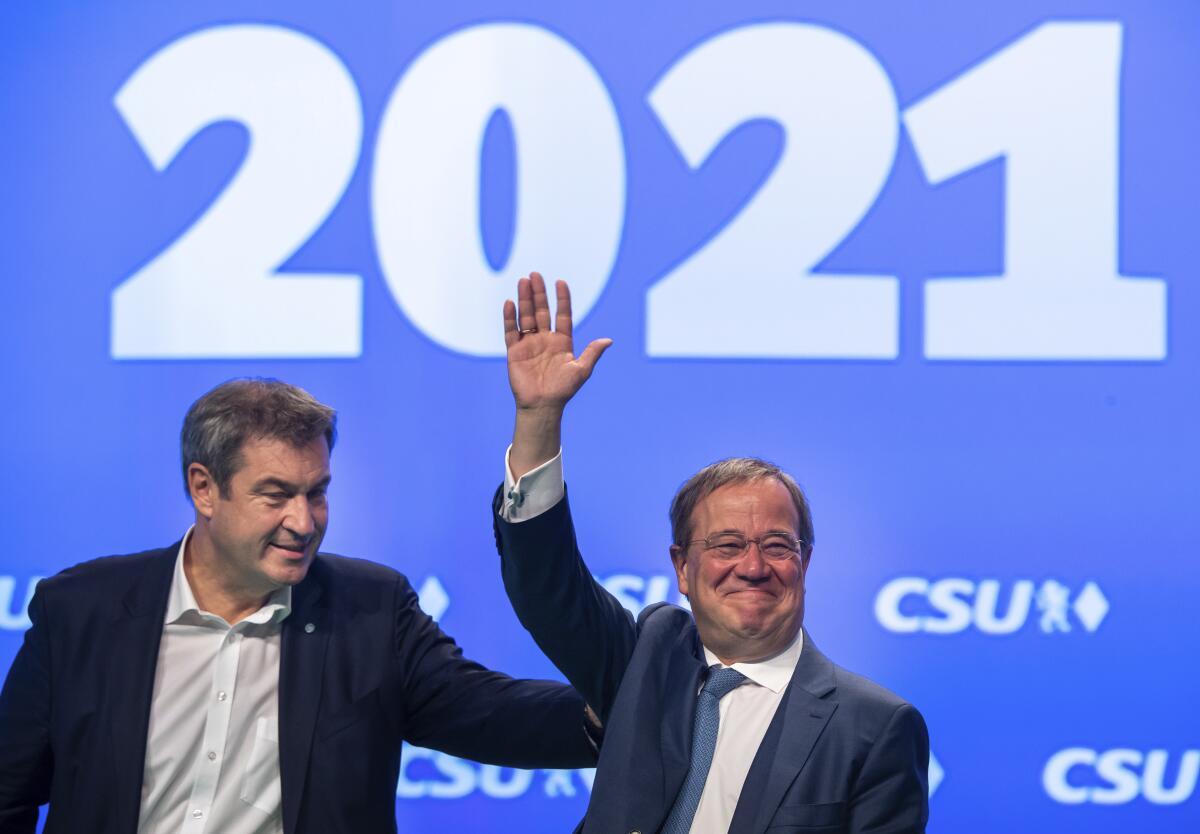 Markus Söder, left, CSU party leader and prime minister of Bavaria, and Armin Laschet, CDU/CSU candidate for chancellor, are on stage together at the CSU party conference in Nuremberg, Germany, Saturday, Sept.11, 2021. It is the first attendance party conference of the CSU since the outbreak of the Corona pandemic. (Peter Kneffel/dpa via AP)