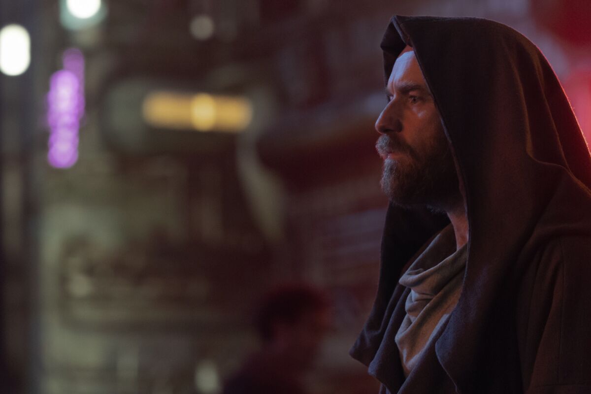 the profile of a bearded man in a hooded cloak