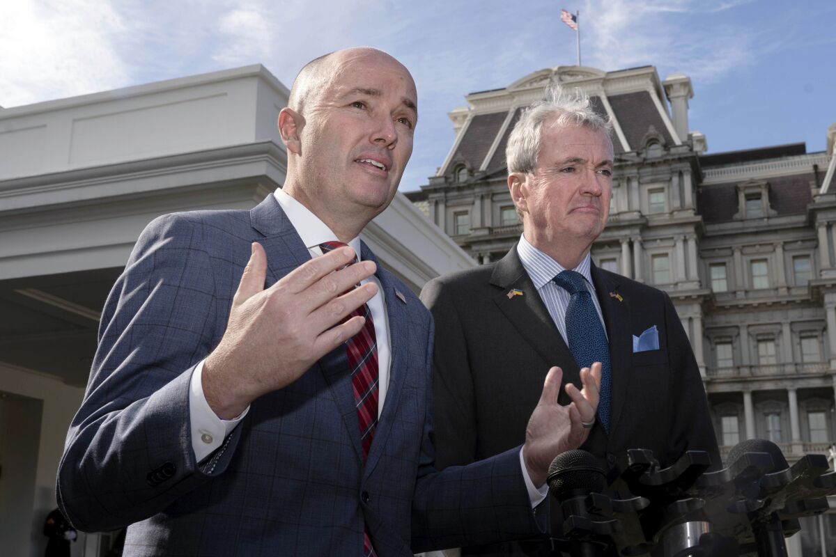 At left, Spencer Cox and, right, Phil Murphy speak to reporters outside the West Wing of the White House in Washington