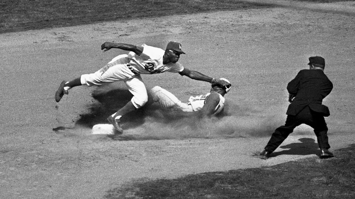 Dodger's Jim Gilliam makes a tag as Cincinnati Reds' Tommy Harper slides safely into second during the sixth inning.