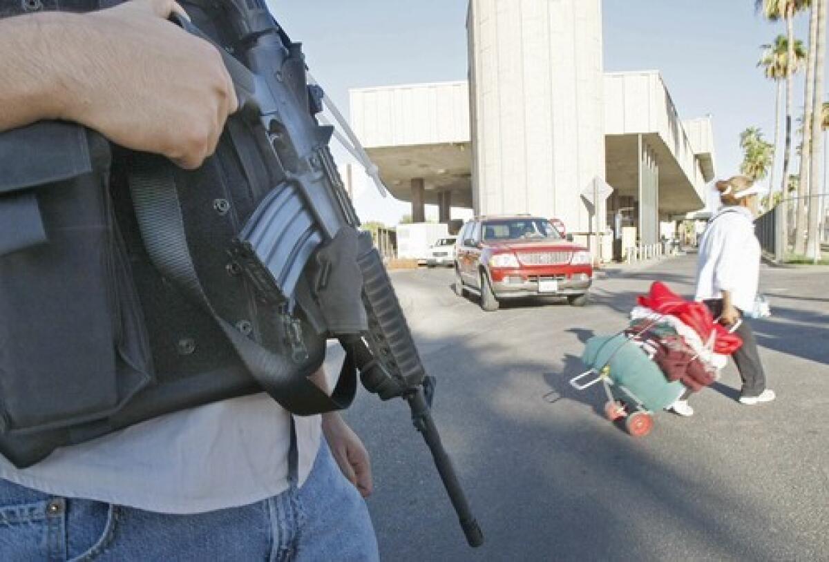 A heavily armed police officer in Calexico keeps an eye on border crossers from Mexicali, Mexico.