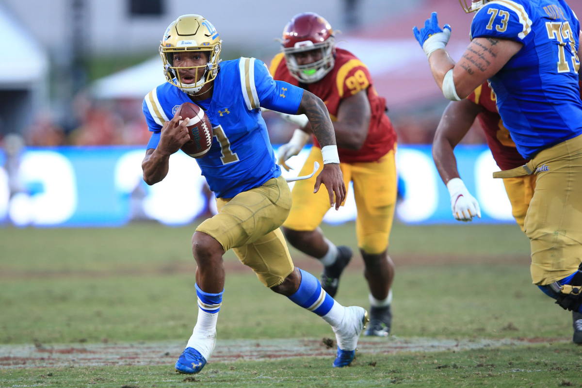 Dorian Thompson-Robinson, carrying the ball, breaks from the pocket for extra yards in a game against USC.