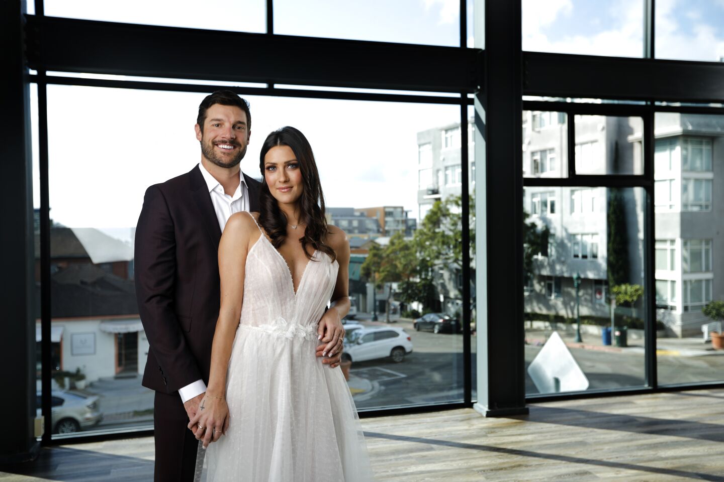 THEY DO: Becca Kufrin and Garret Yrigoyen practice for their future wedding by posing in bridal inspired clothing at the Porto Vista Hotel. On Becca: Flora dress, The Dress Theory, thedresstheory.com; Ari necklace and Zorte hair clip, Kendra Scott, kendrascott.com. On Garrett: Astian suit, Hugo Boss, Irving shirt, Theory, bloomingdales.com; sneakers by Gola, golausa.com.