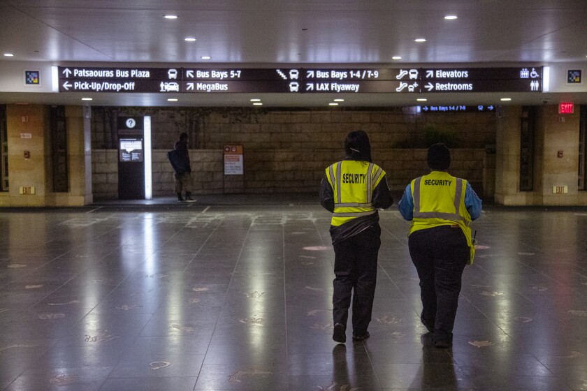 Security guards in neon yellow vests walk through Union Station