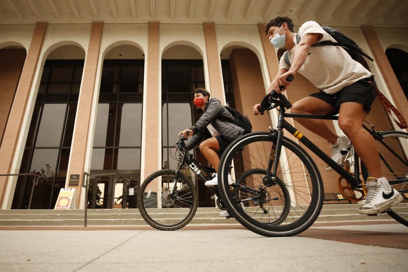 LOS ANGELES, CA - AUGUST 23: Brothers Ryan, right, and Evan Abdollahi, from Orange County ride to their classes on the USC campus Monday for the first day of in-person classes. Ryan is a sophomore, and Evan is a freshman but this is the first full-time on-campus experience for both. USC and California State University campuses start in-person classes on Monday, serving as a test case for whether vaccine mandates, masking, regular testing and other protocols can minimize spread of the Delta variant even as thousands of students congregate in classes, dorms and social events. USC campus on Monday, Aug. 23, 2021 in Los Angeles, CA. (Al Seib / Los Angeles Times).