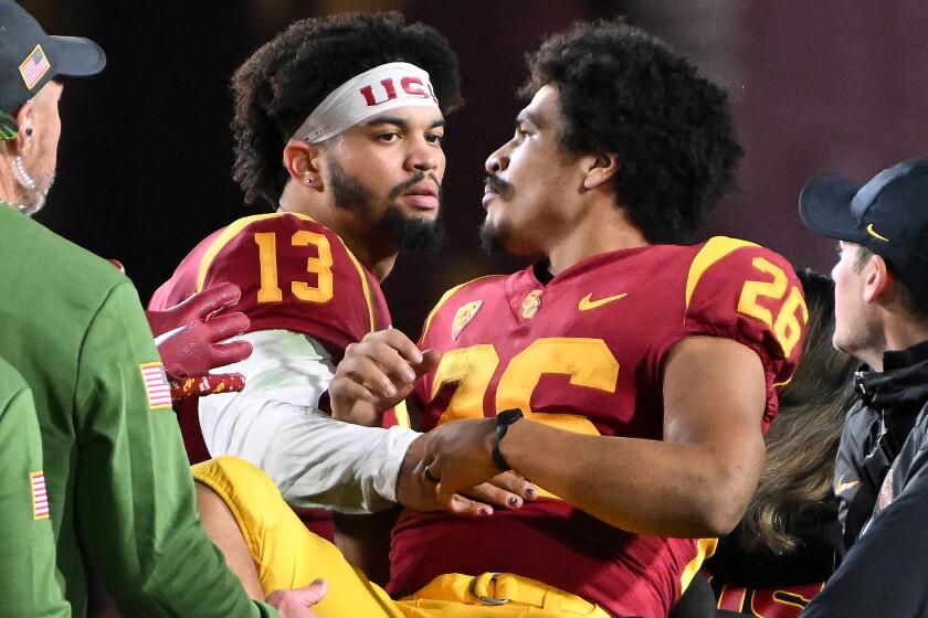 USC running back Travis Dye is consoled by quarterback Caleb Williams.