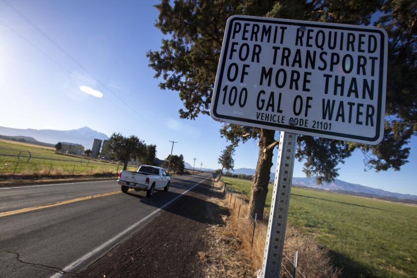 MOUNT SHASTA VISTA, CA - October 14 2021: A road sign near an entrance to the Mount Shasta Vista subdivision warns of a recently passed ordinance requiring permits to haul more than 100 gallons of water on roads leading to the subdivision on Thursday, Oct. 14, 2021 in Mount Shasta Vista, CA. (Brian van der Brug / Los Angeles Times)