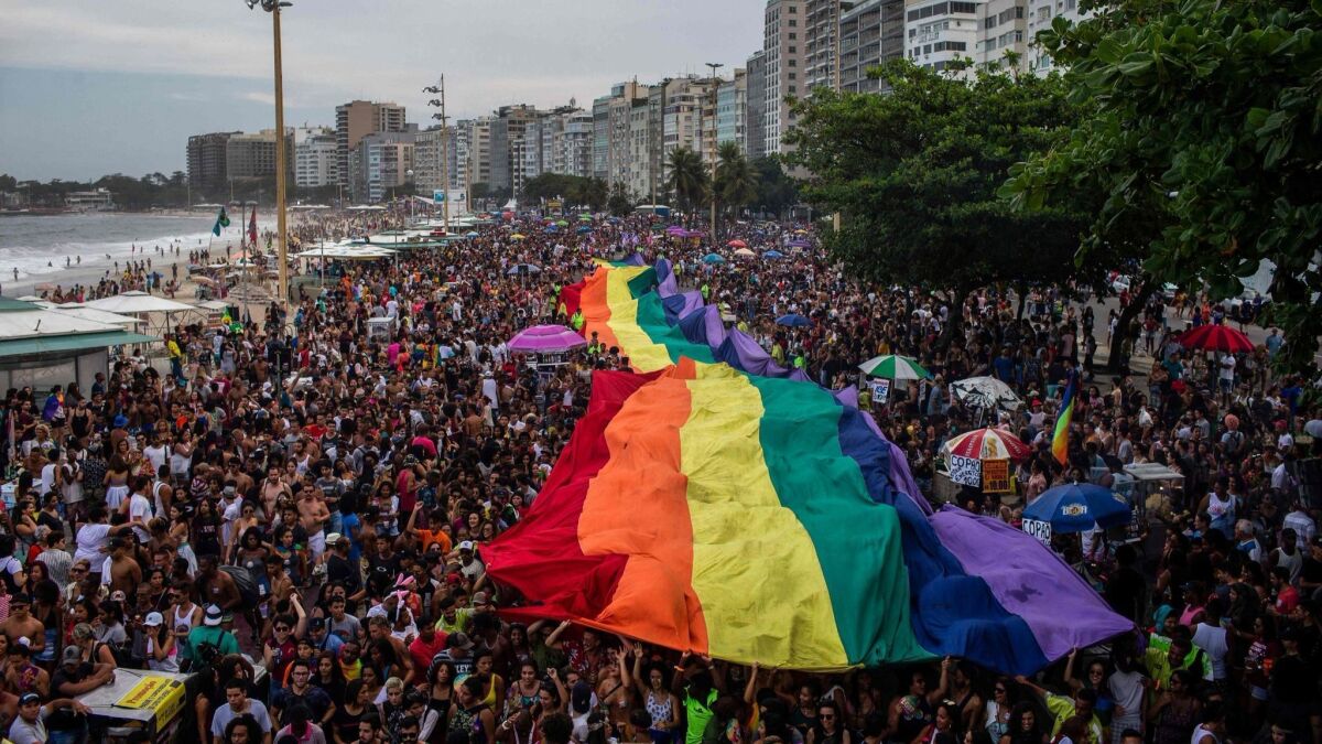 Participants hold up a giant rainbow flag during a gay pride parade at Copacabana Beach in Rio de Janeiro on Sept. 30.