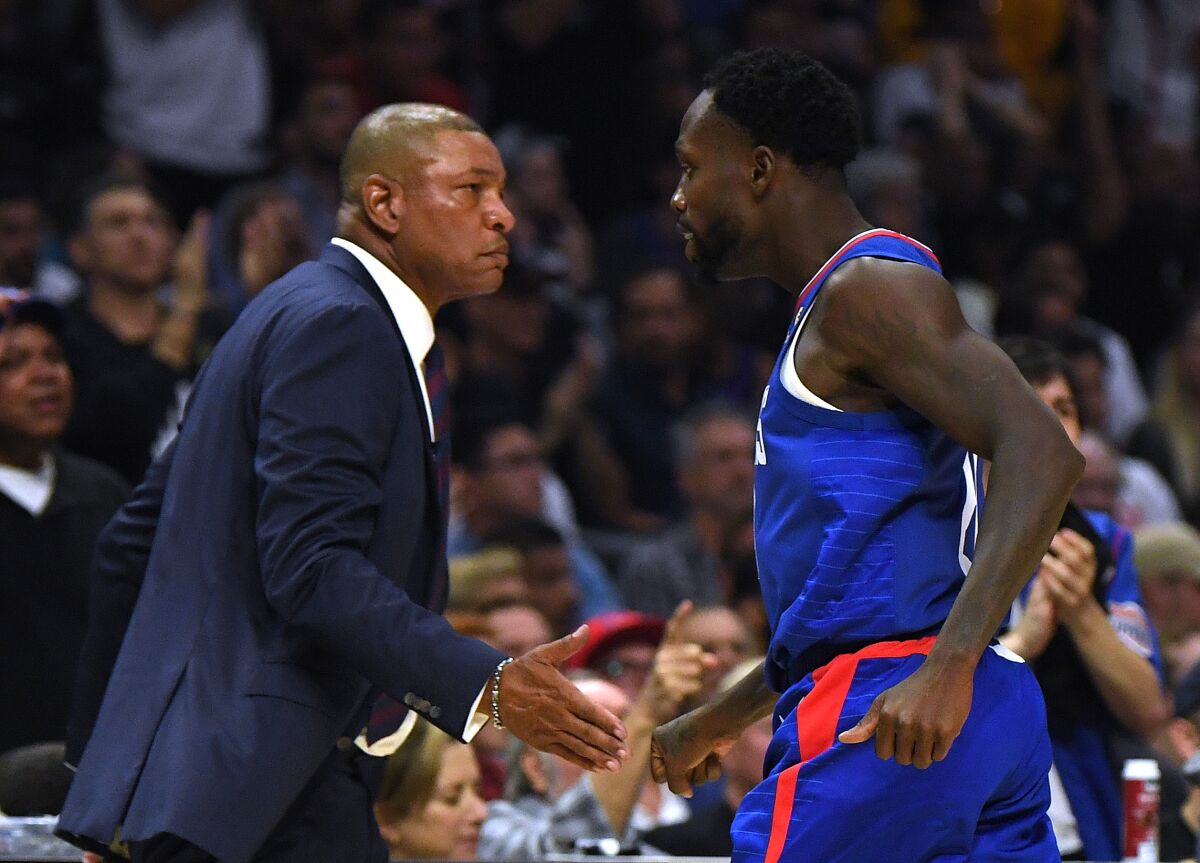 Clippers guard Patrick Beverley celebrates with coach Doc Rivers.