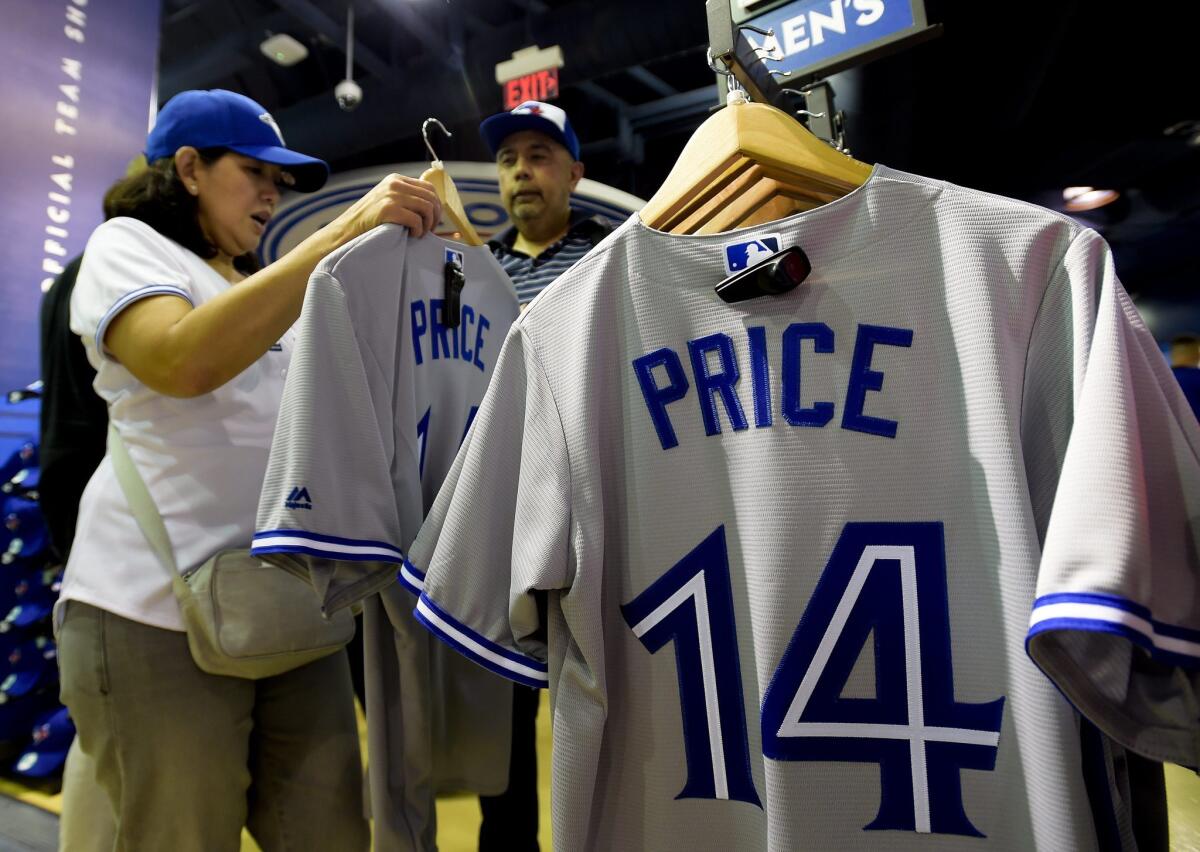 Toronto Blue Jays fans tries on the jersey of newly acquired pitcher David Price before the Blue Jays play the Kansas City Royals during a baseball game, Thursday, July 30, 2015 in Toronto. (Nathan Denette/The Canadian Press via AP) MANDATORY CREDIT