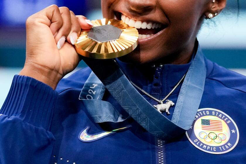 Simone Biles, of the United States, celebrates after winning the gold medal during the women's artistic gymnastics all-around finals in Bercy Arena at the 2024 Summer Olympics, Thursday, Aug. 1, 2024, in Paris, France. (AP Photo/Abbie Parr)