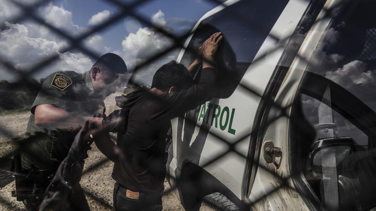 Border Patrol agent Rene Cisneros frisks Tom de Huachac, 33, who the agent said was apprehended while attempting to cross the U.S.-Mexico border in McAllen, Texas. De Huachac said he is from Guatemala.