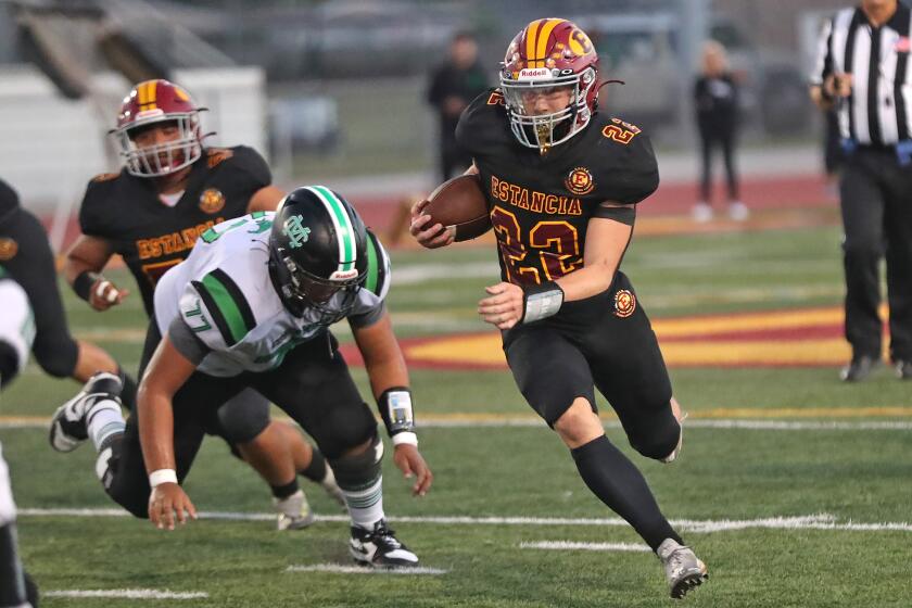 Estancia's Jeff Brown (22) runs around the end for big gain during annual Battle of the Bell football game against cross-town rival Costa Mesa on Friday at Estancia High.