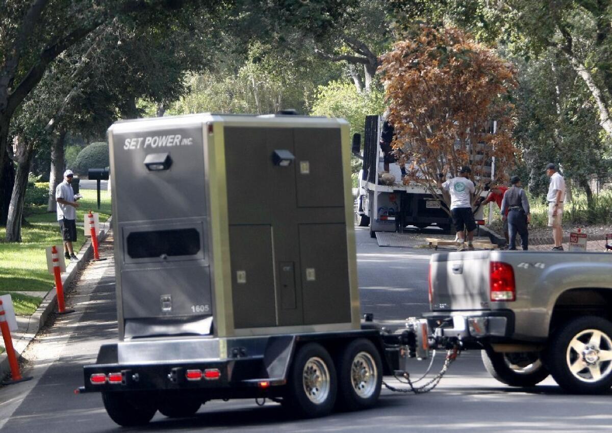 Film production crews unload trees as other crews arrive with portable power at 4159 Commonwealth Ave., in La Canada Flintridge. Some neighbors do not like the frequency of filming at this home.