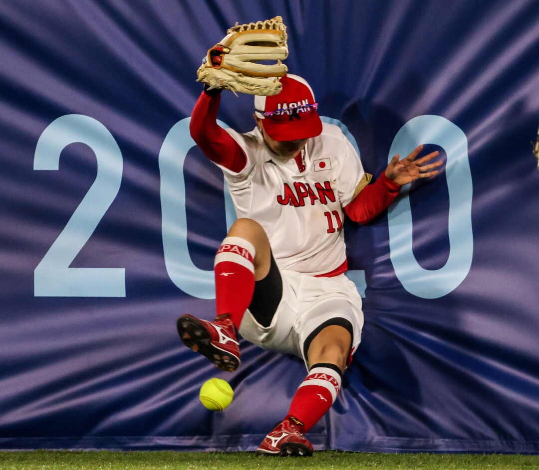 July 27: Team Japan outfielder Eri Yamada misses a catch while crashing into the right field wall