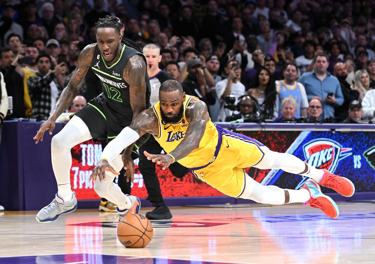 The Lakers' LeBron James dives for the ball in front of the Timberwolves' Taurean Prince 