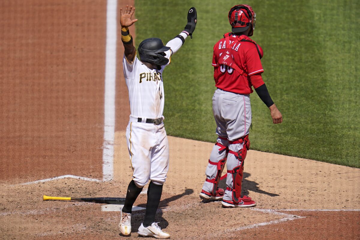 Pittsburgh Pirates' Rodolfo Castro, left, celebrates as teammate Ke'Bryan Hayes (not shown) beats out a fielder's choice, allowing Castro to score from third, during the eighth inning of a baseball game against the Cincinnati Reds in Pittsburgh, Sunday, May 15, 2022. (AP Photo/Gene J. Puskar)