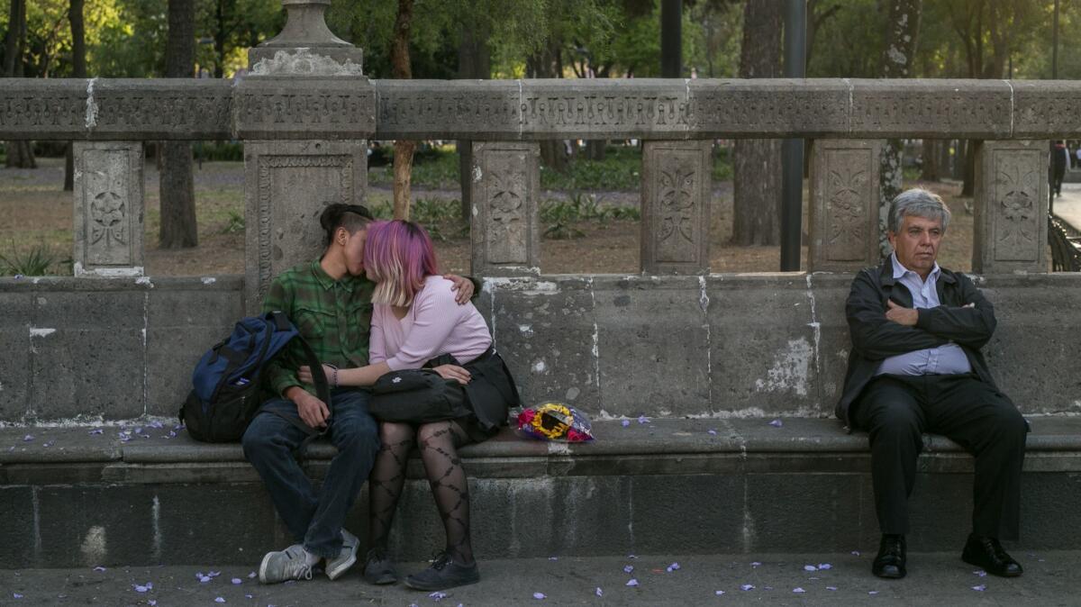 A young couple kisses in Mexico City. "Our parents think we're in class," they explained.