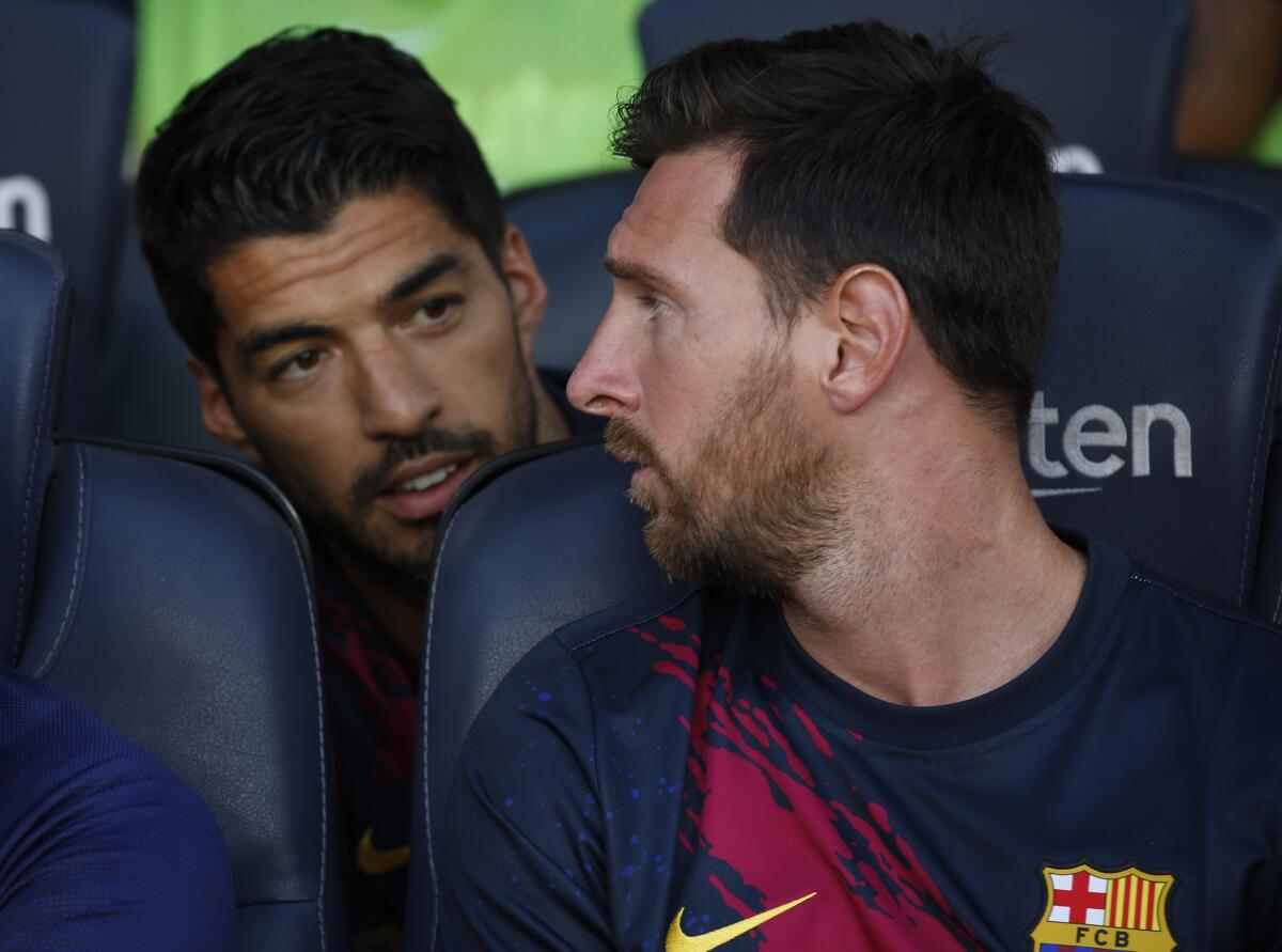 ARCHIVO - el argentino Lionel Messi, derecha, dialoga con su compañero Luis Suárez