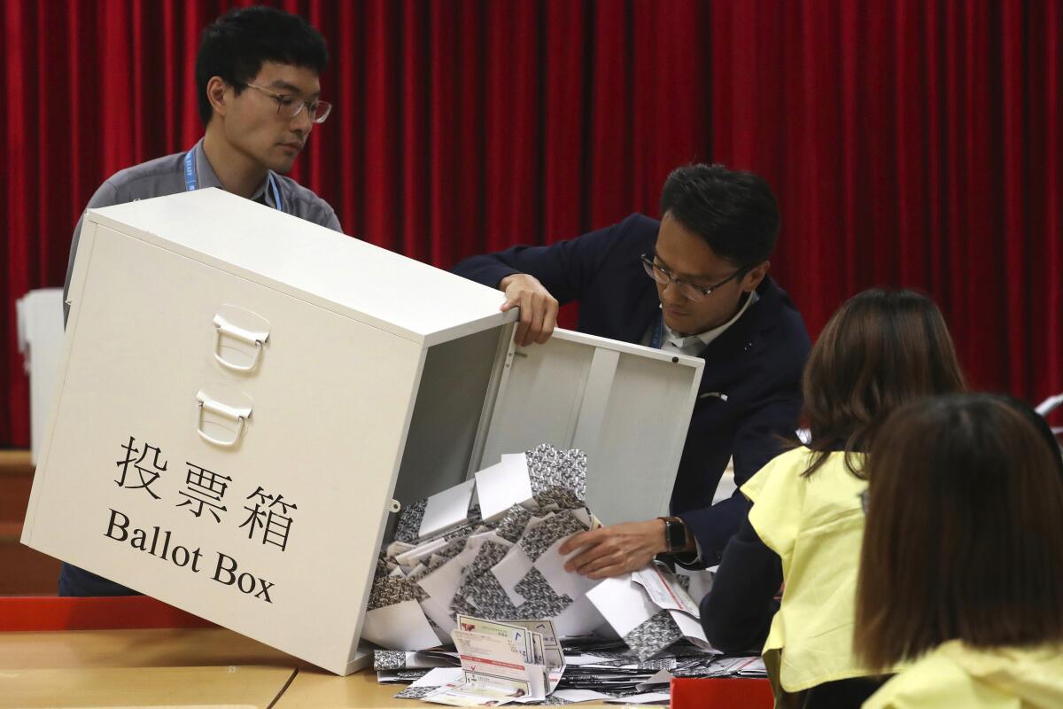 Election workers empty a ballot box to count votes
