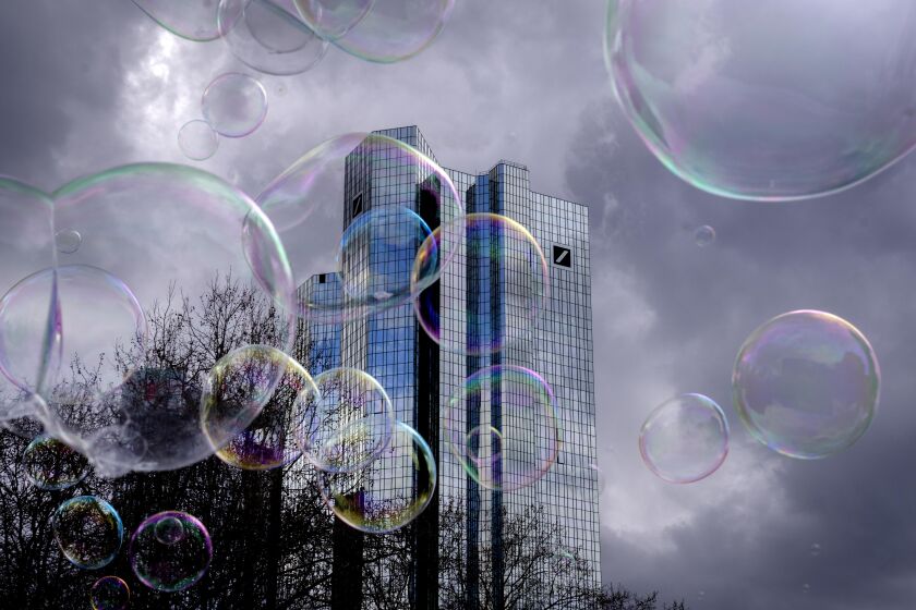 Bubbles made by a soap bubble artist, fly in front of the headquarters of Deutsche Bank in Frankfurt, Germany, Friday, March 24, 2023. (AP Photo/Michael Probst)