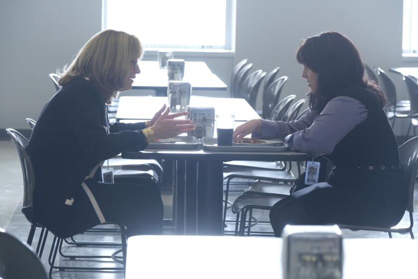 Two women eat lunch in an empty office cafeteria
