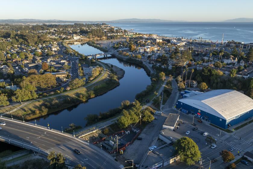 Santa Cruz, CA - November 21: The San Lorenzo River courses past Kaiser Permanente Arena, right, home of the the Santa Cruz Warriors of the NBA G league, in an area where the city plans new high-rise development on Tuesday, Nov. 21, 2023 in Santa Cruz, CA. (Brian van der Brug / Los Angeles Times)