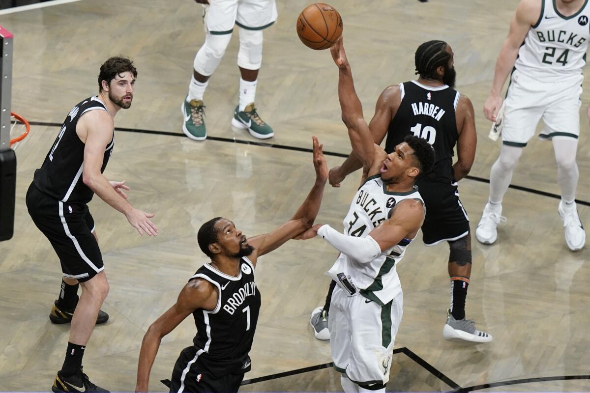 The Milwaukee Bucks' Giannis Antetokounmpo shoots over the Brooklyn Nets' Kevin Durant during overtime June 19, 2021.