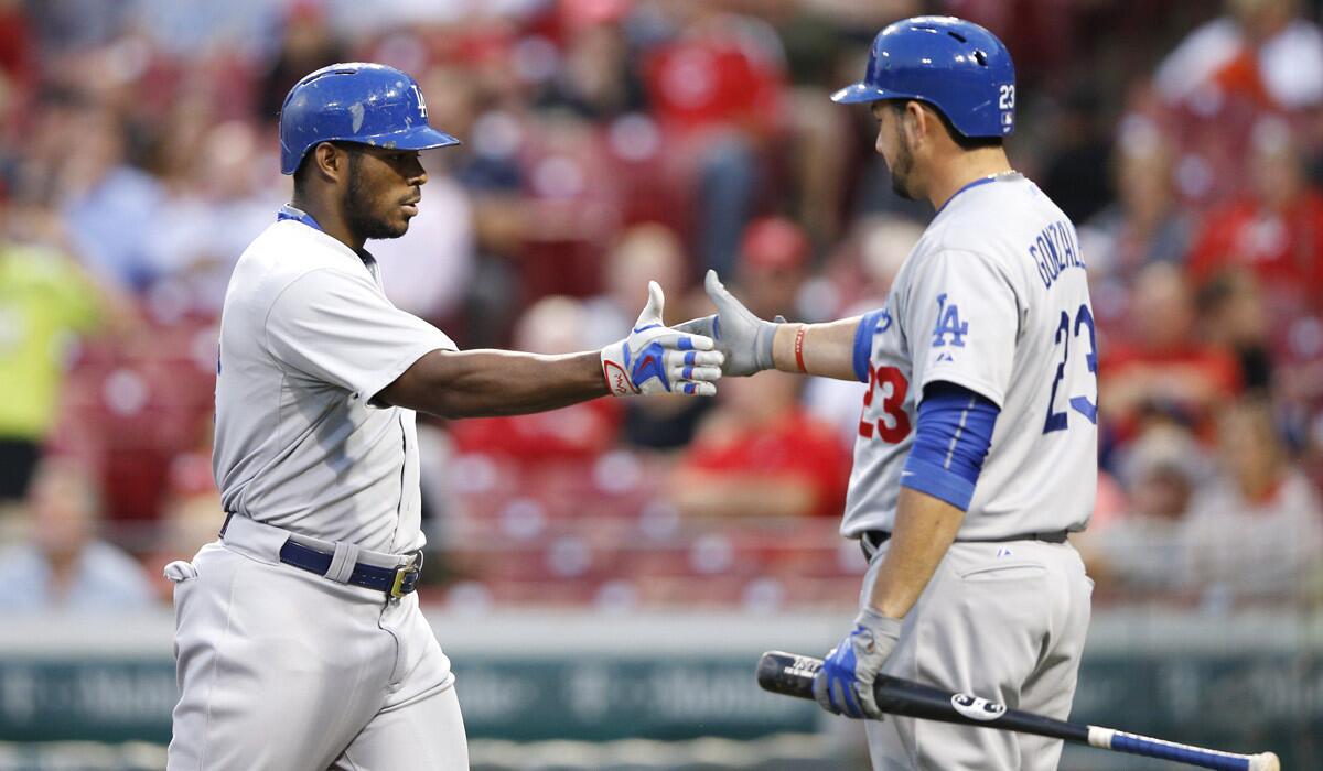 Dodgers' Yasiel Puig is congratulated by Adrian Gonzalez after hitting a two-run home run in the fourth inning against the Cincinnati Reds on Wednesday.